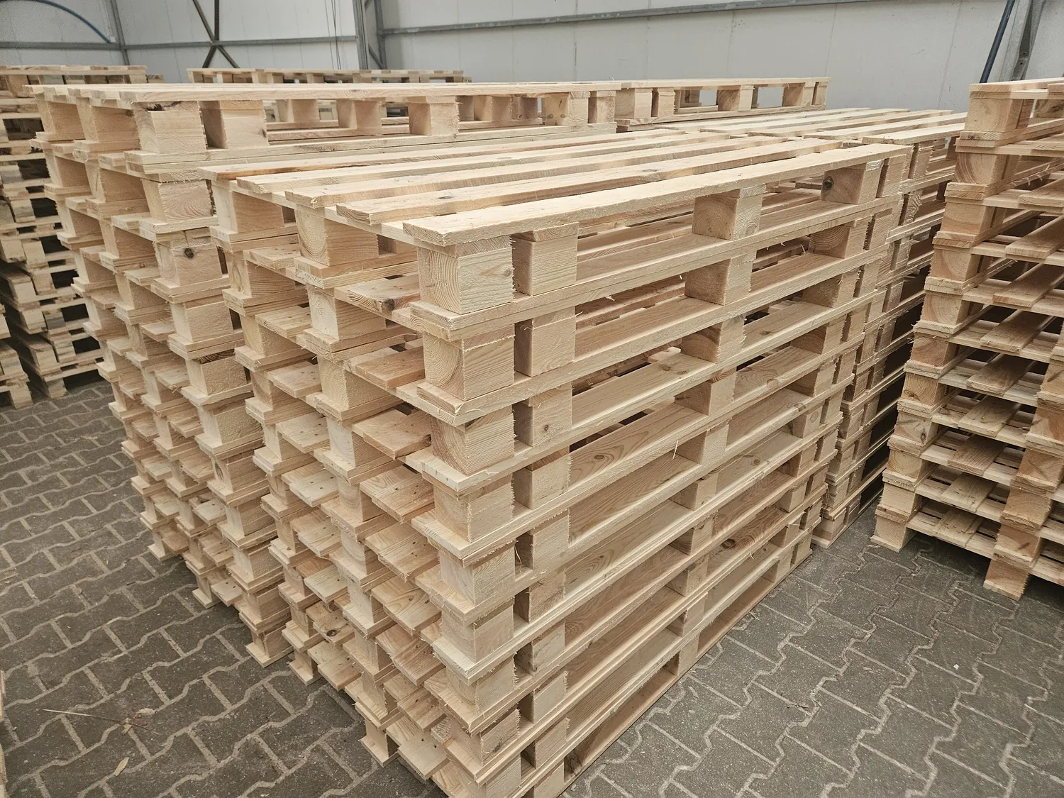 Palety przemysłowe ułożone w stosy po zakończonej produkcji