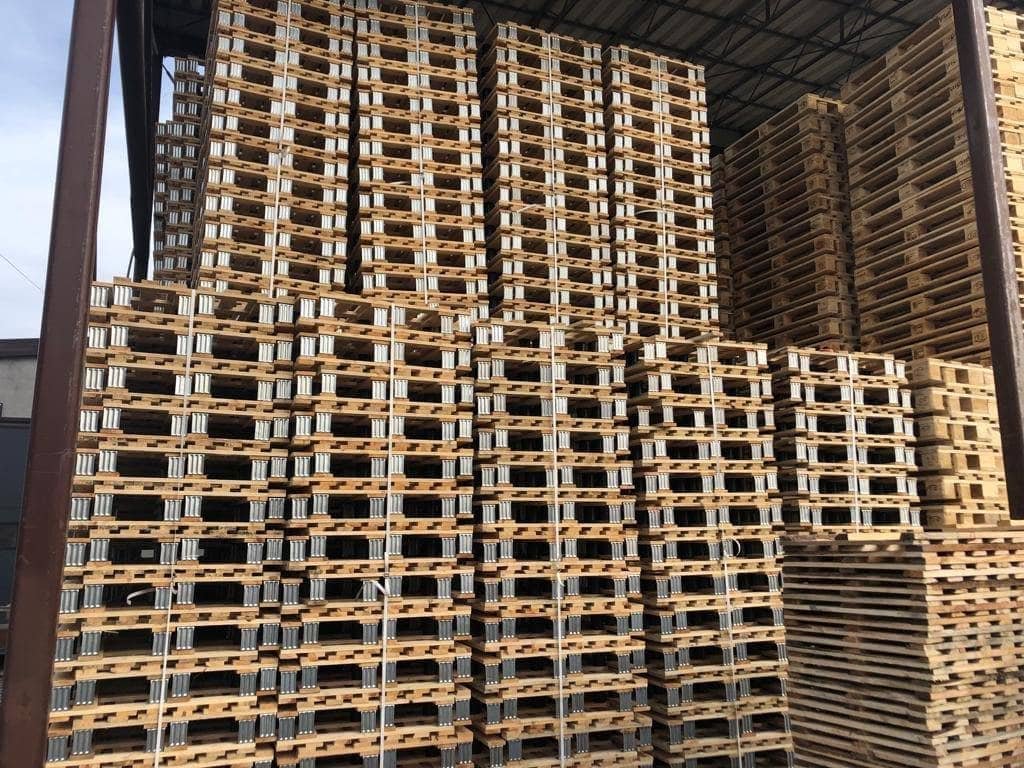 Magazyn palet — stosy ustawione pod wiatą produkcyjną